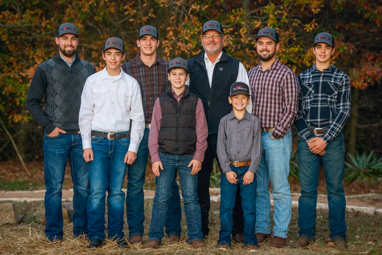 Pro Movers family portrait: father and six sons in matching hats, smiling outdoors.